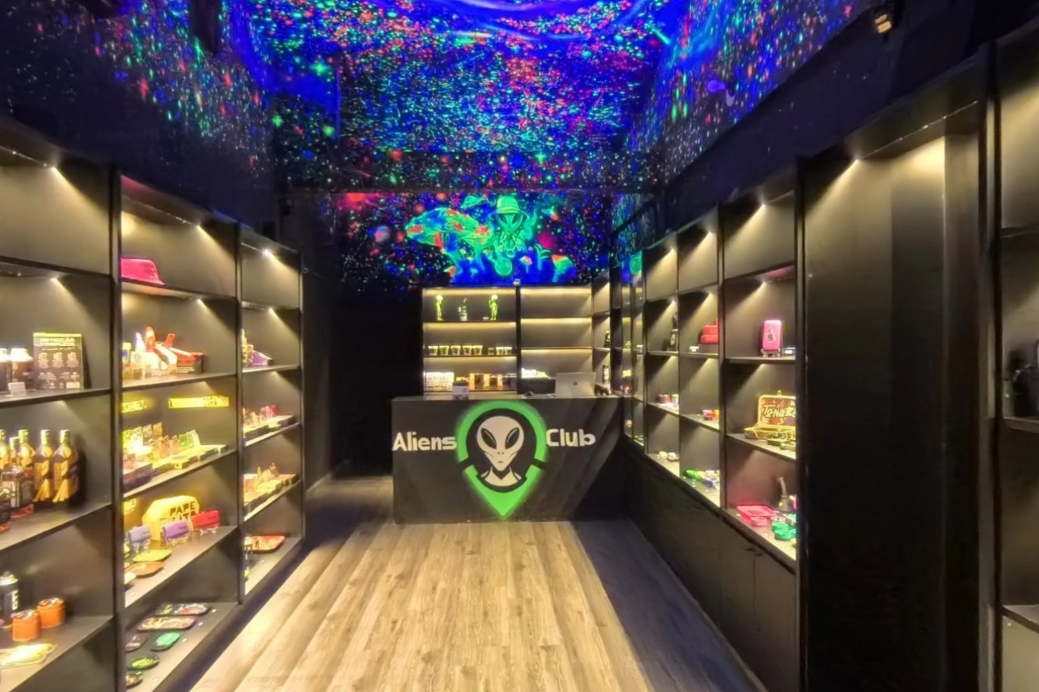 Loja com prateleiras iluminadas e teto de galáxia em neon, capturada em 360°