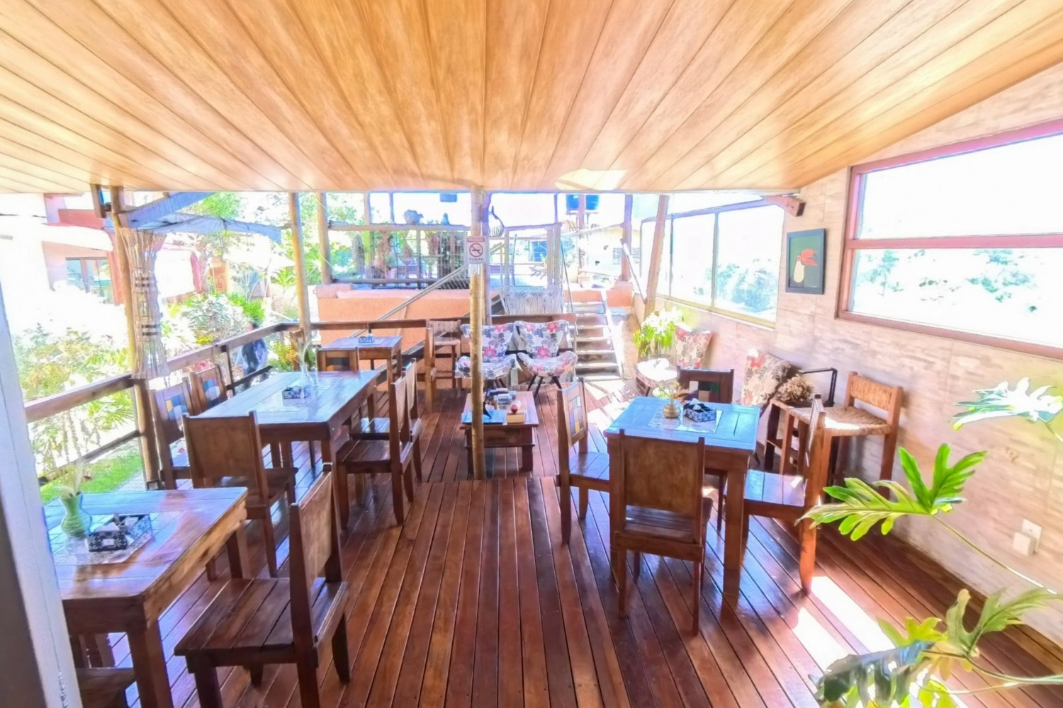 Restaurante de pousada com forro de madeira e mesas postas, capturado em 360°